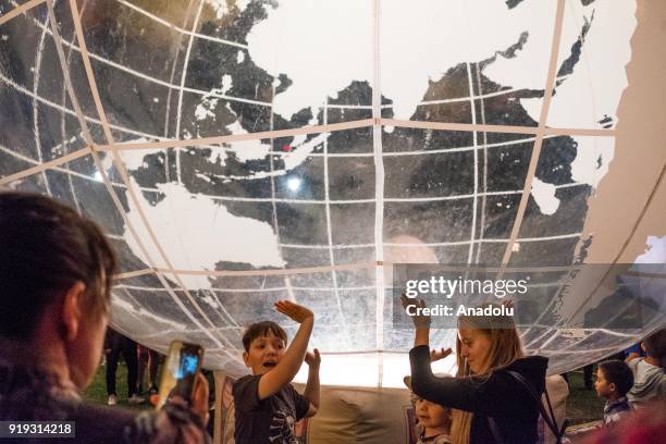 Children hold up a inflatable display of the earth as part of the La Terra Al Centro Dell Universo display during the White Night Melbourne festival...