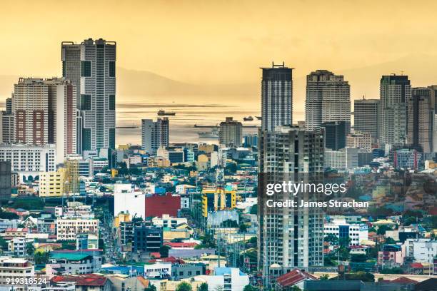 aerial cityscape at dusk (sulphurous sky from recent volcanic eruptions) with the port in the distance, manila, philippines - national capital region philippines stock-fotos und bilder