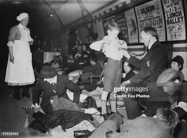 British Red Cross staff examine patients sheltering in Piccadilly underground station during World War II, January 1941.