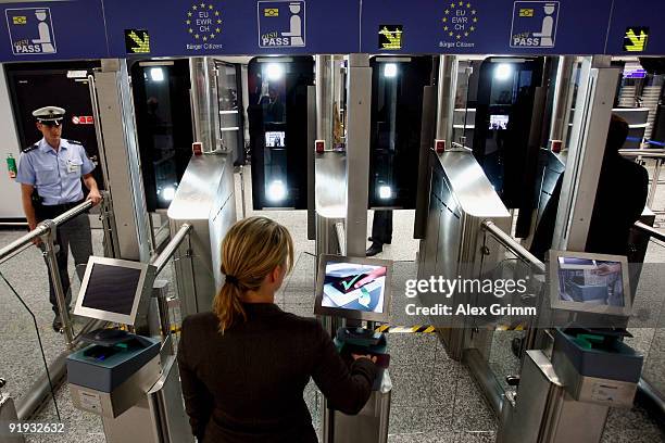 Woman puts her passport into a reader during the presentation of the new automated border control system easyPass at Frankfurt International Airport...