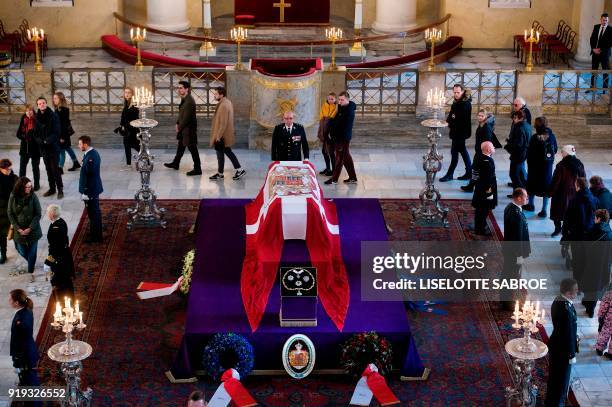 People line up inside Christiansborg Palace Church to see the coffin of late Price Henrik n Castrum Doloris in Copenhagen on February 17, 2018. - The...