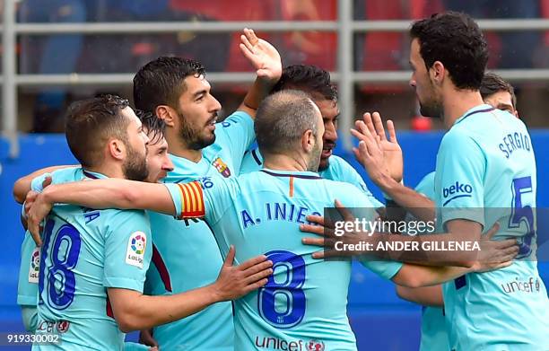 Barcelona's Uruguayan forward Luis Suarez celebrates scoring the opening goal with teammates during the Spanish league football match between SD...