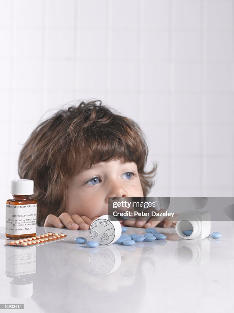 Child putting medicine pill in mouth