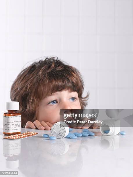 child putting medicine pill in mouth - child proof imagens e fotografias de stock