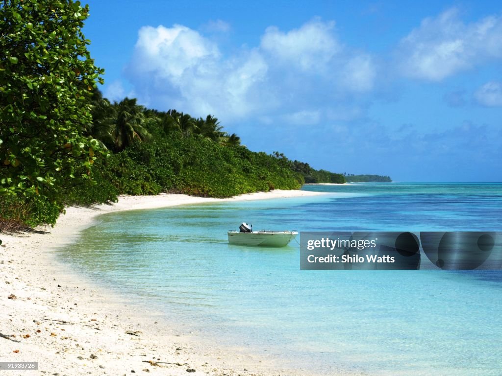 Lone boat in a lagoon next to beautiful beach