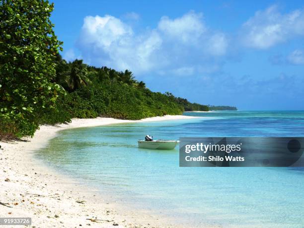 lone boat in a lagoon next to beautiful beach - marshalleilanden stockfoto's en -beelden