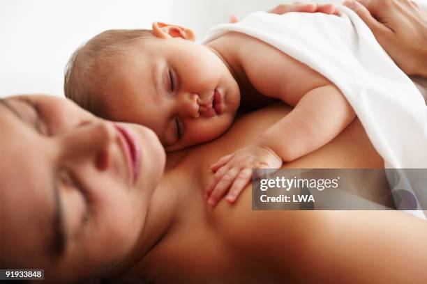 infant daughter sleeping on mother's chest - touching skin stock pictures, royalty-free photos & images