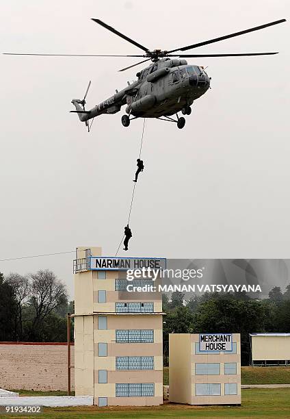 National Security Guards commandos re-enact their counter-terrorism operations in the 2008 Mumbai militant attacks during a function to celebrate the...