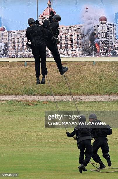National Security Guards commandos re-enact their counter-terrorism operations in the 2008 Mumbai militant attacks during a function to celebrate the...