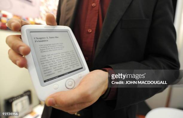 An employee at the Bookeen stand displays the company's new Cybook Opus e-book at the 61st Frankfurt Book Fair in Frankfurt October 16, 2009. The...