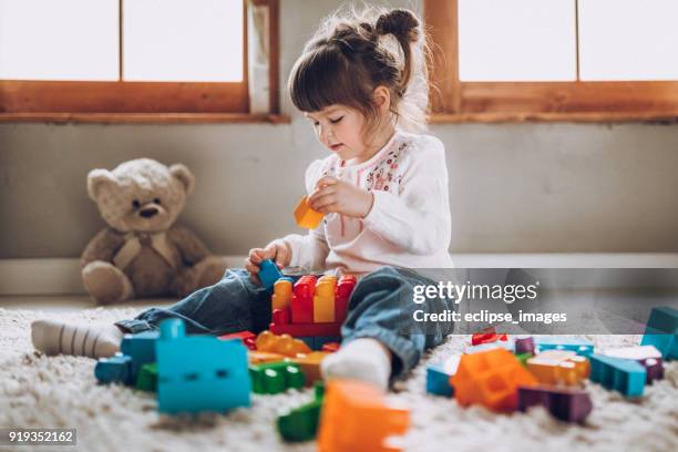 sweet child playing with plastic blocks - plastic toy stock pictures, royalty-free photos & images