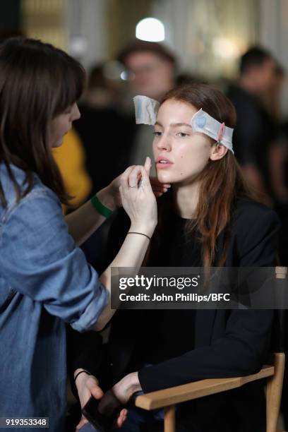 Model has makeup applied backstage ahead of the Jasper Conran show during London Fashion Week February 2018 at Claridges Hotel on February 17, 2018...