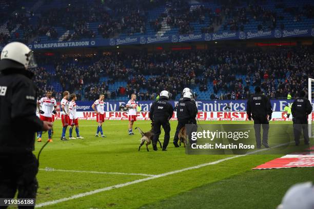 Police forces enter the pitch with dogs in front of the Hamburg stand after the Bundesliga match between Hamburger SV and Bayer 04 Leverkusen at...