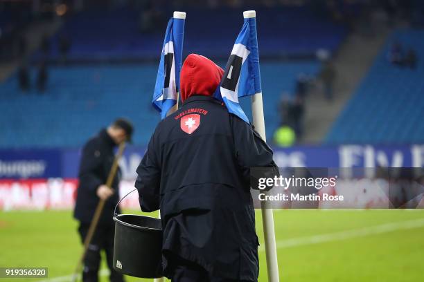 Green keeper carries the corner flags away after the Bundesliga match between Hamburger SV and Bayer 04 Leverkusen at Volksparkstadion on February...