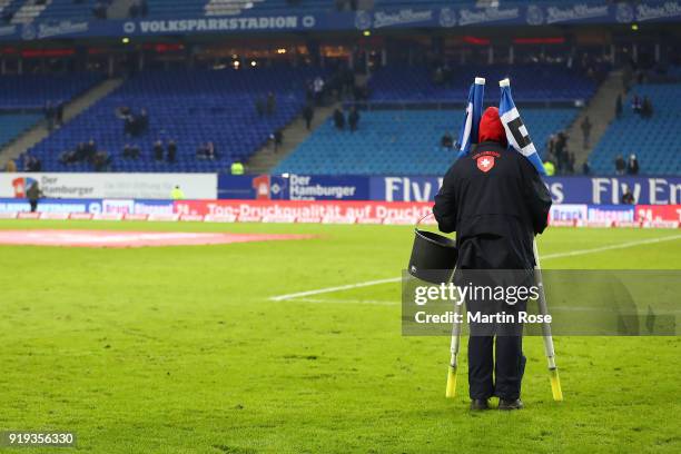 Green keeper carries the corner flags away after the Bundesliga match between Hamburger SV and Bayer 04 Leverkusen at Volksparkstadion on February...