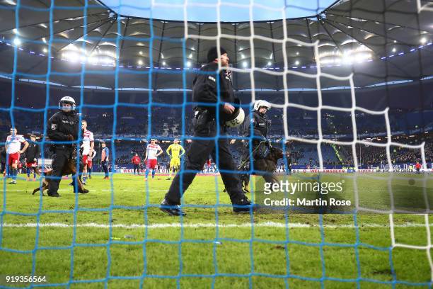 Police forces enter the pitch with dogs in front of the Hamburg stand after the Bundesliga match between Hamburger SV and Bayer 04 Leverkusen at...