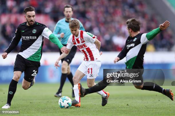 Vincent Koziello of Koeln is challenged by Kenan Karaman and Oliver Sorg of Hannover during the Bundesliga match between 1. FC Koeln and Hannover 96...