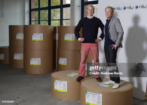 The two German entrepreneurs Wanja Soeren Oberhof and Hendrik Tiedemann of Niiu, the world's first individualised newspaper, stand up on huge paper...