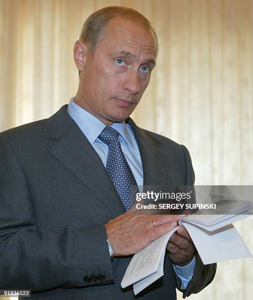 Russian President Vladimir Putin examines documents prior his meeting with heads of Commonwealth of Independent States at the Mukholatka residence,...