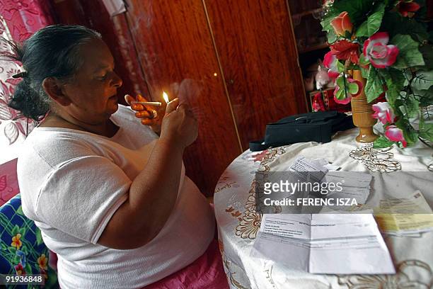 Hongrie: les Roms d'Esztergom entre taudis et chômage Hungarian gypsy grandmother Joli lights a cigarette above her bills at Toltes street in...
