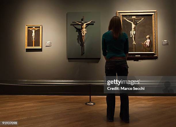 National Gallery employee stands in front of three paintings of Crucifixion by Francisco Paceco, Juan de Mesa and Francisco de Zurbaran at 'The...