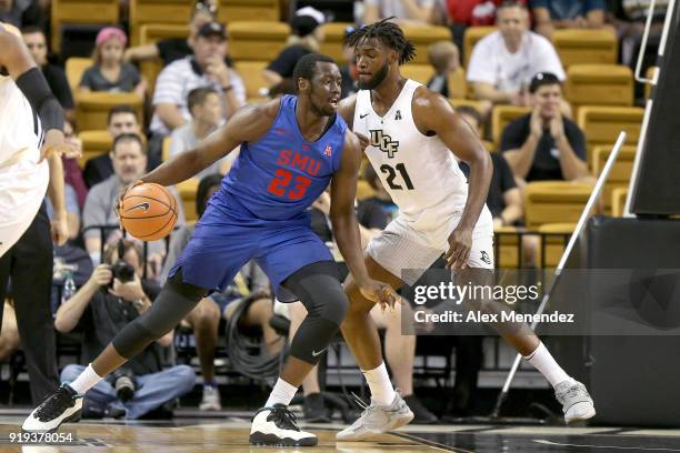 Akoy Agau of the Southern Methodist Mustangs dribbles in front of Chad Brown of the UCF Knights during a NCAA basketball game at the CFE Arena on...