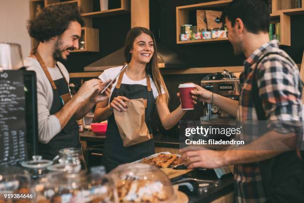 man taking his order at a coffee shop - movement makers stock pictures, royalty-free photos & images
