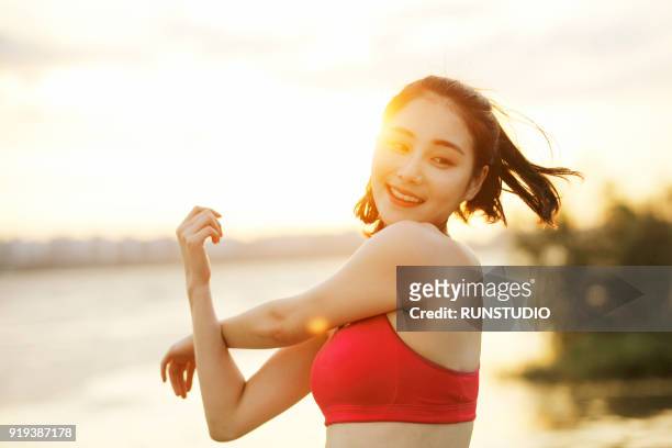 woman stretching  arms at riverside - woman stretching ストックフォトと画像