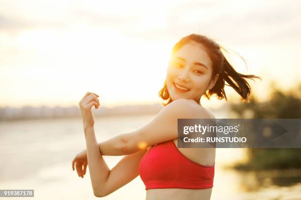 woman stretching  arms at riverside - runner warming up stock pictures, royalty-free photos & images