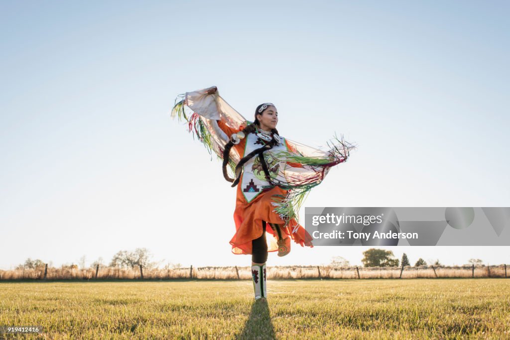 Young Native American woman dancing in traditional dress