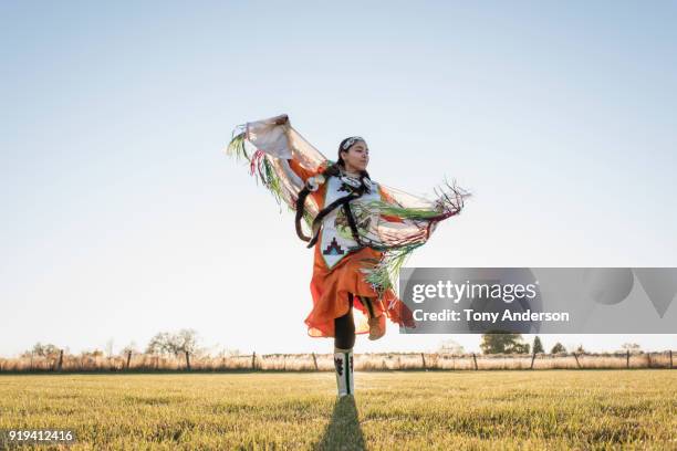 young native american woman dancing in traditional dress - inheemse bevolking stockfoto's en -beelden