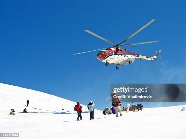 a helicopter hovering over a group of hikers on snow - frige bildbanksfoton och bilder