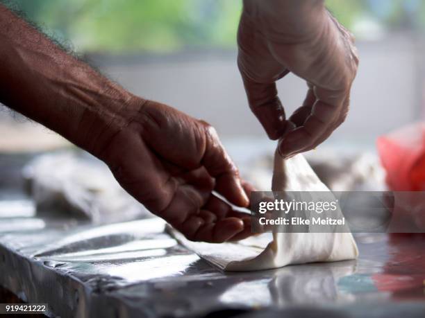 close up of hands folding a samosa - samosa stock pictures, royalty-free photos & images