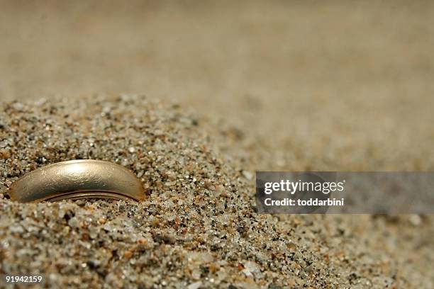 gold hochzeit ring lost in the sand - golden sand stock-fotos und bilder