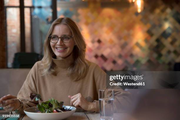 portrait of businesswoman having lunch in a restaurant - blond women happy eating stock pictures, royalty-free photos & images