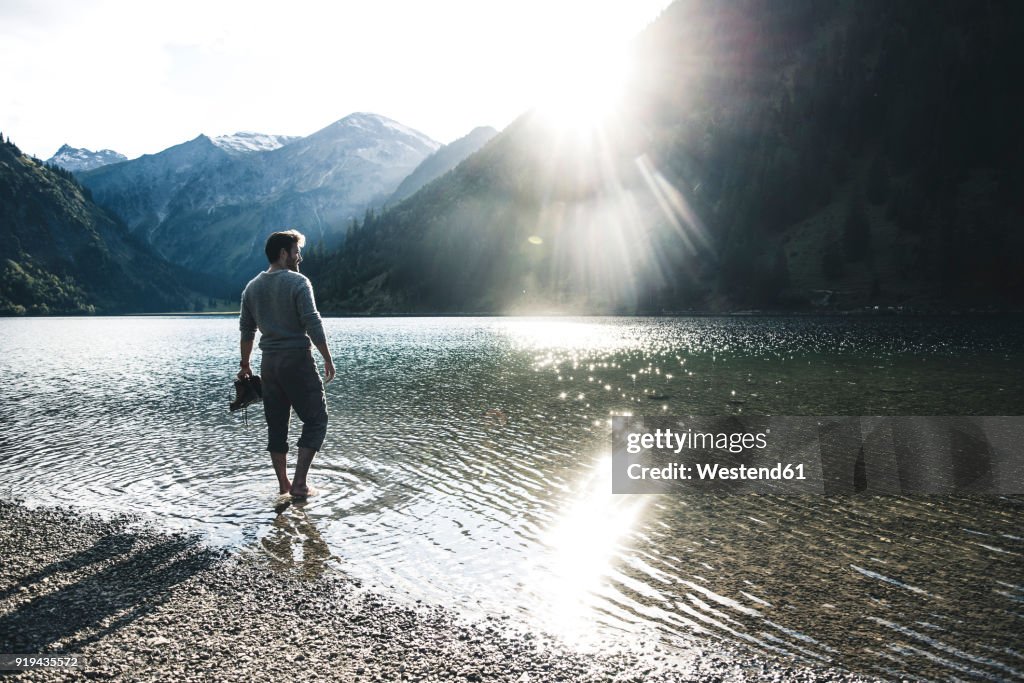 Austria, Tyrol, hiker refreshing in mountain lake