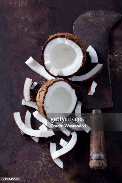 opened coconut, cocontu pieces and an old cleaver - half open stock pictures, royalty-free photos & images