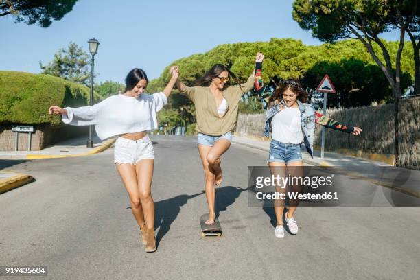 three friends having fun together - women in daisy dukes stockfoto's en -beelden
