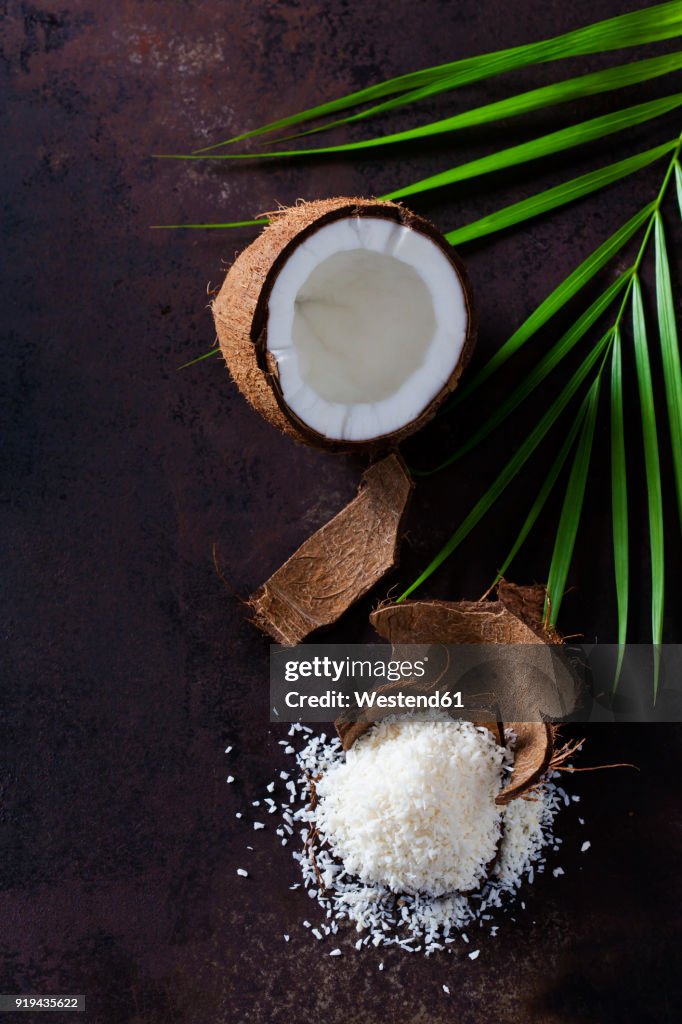 Opened coconut, coconut husk and pile of coconut flakes