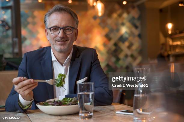 portrait of businessman having lunch in a restaurant - one man only stock pictures, royalty-free photos & images