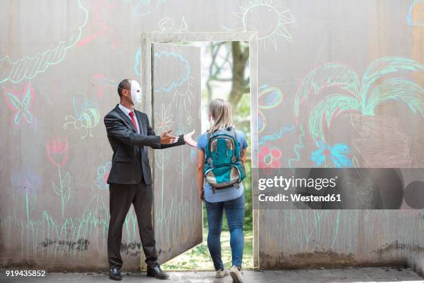 businessman wearing mask showing young woman way through concrete wall - secret door drawing stock pictures, royalty-free photos & images