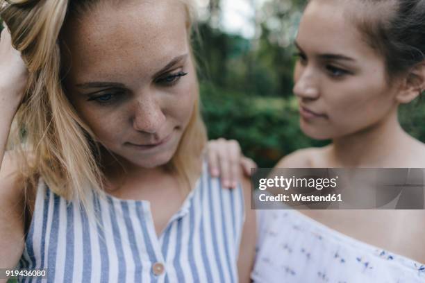 young woman comforting sad female friend - pessimism stock pictures, royalty-free photos & images