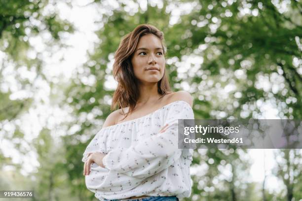 portrait of young woman in a park - looking around stock pictures, royalty-free photos & images