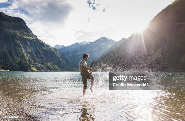 austria, tyrol, hiker splashing in mountain lake - état fédéré du tyrol photos et images de collection