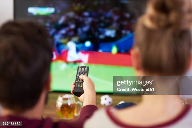 couple watching football match on tv - tv gucken stock-fotos und bilder