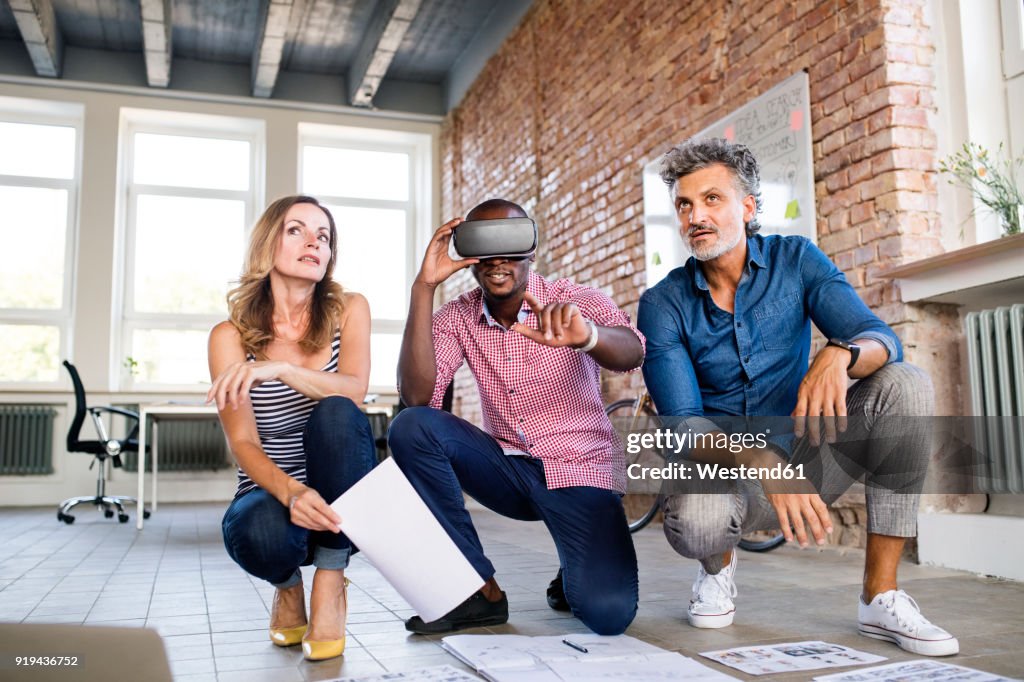 Team of architects discussing the rebuilding of a loft office, using 3D goggles