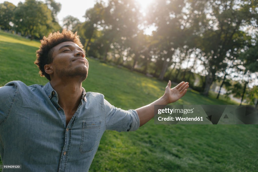 Young man enjoying the sunset in a park