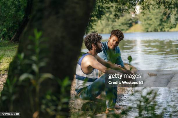 two friends relaxing at the water - friends serious stock pictures, royalty-free photos & images