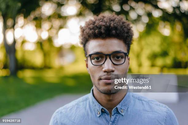 portrait of young man wearing glasses in park - well dressed young man stock pictures, royalty-free photos & images