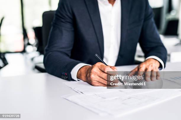 close-up of businessman with documents at desk in office - close up table stock pictures, royalty-free photos & images